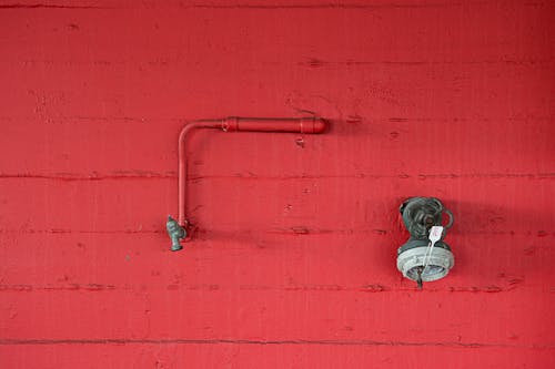 Red Wall with a Faucet