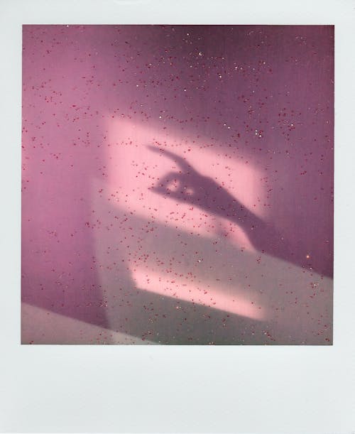Shadow of hand gesture on pink wall