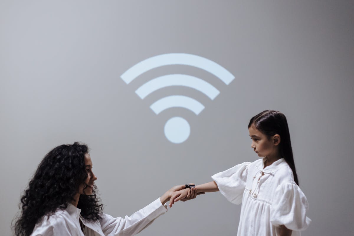 Mother and daughter with smartwatch and Wi-Fi symbol