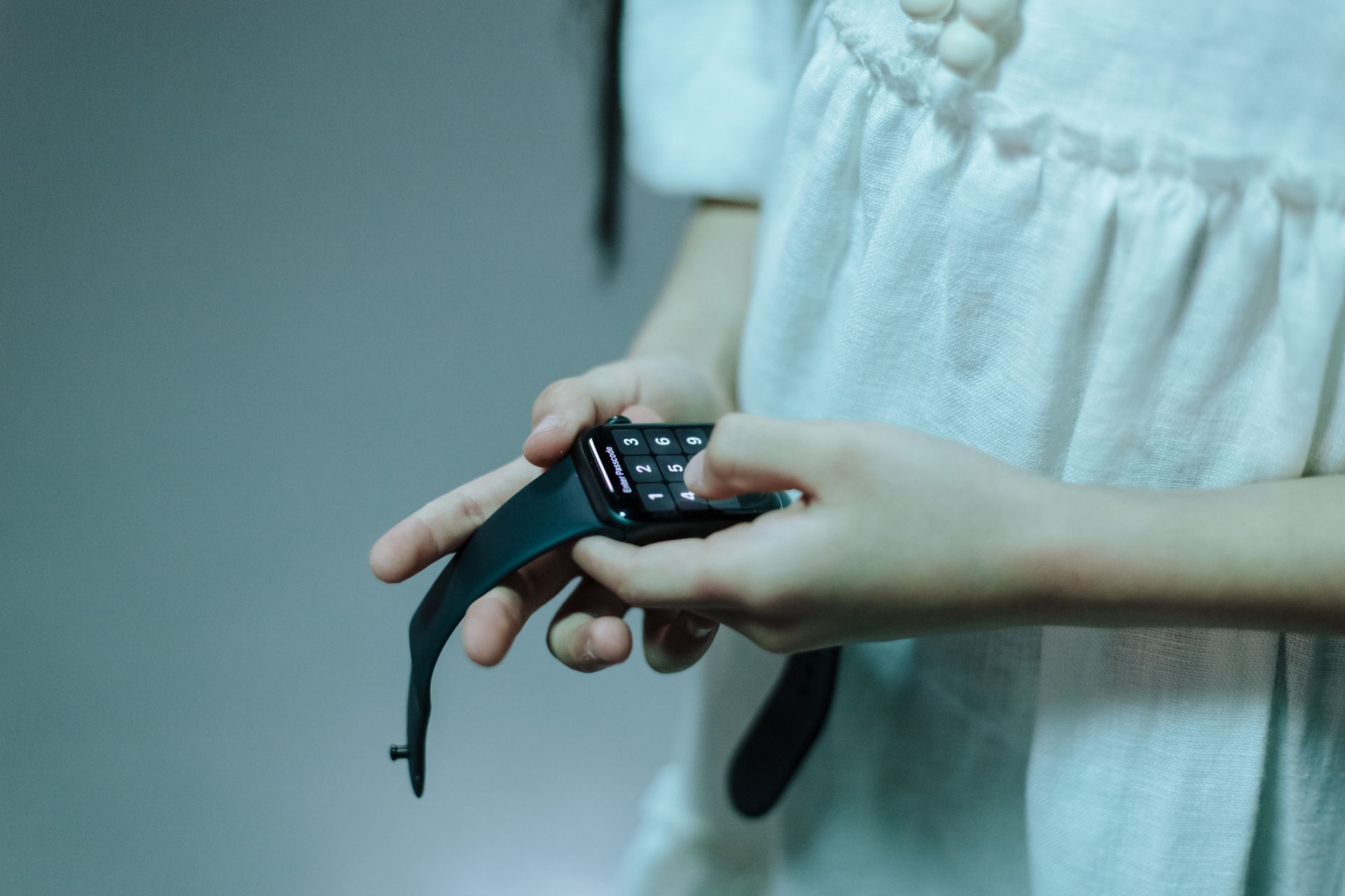 Young girl interacting with a touchscreen smartwatch, focusing on technology use by children.