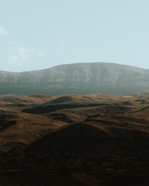 Free A calming view of rolling hills under a vast sky, capturing the essence of untouched nature. Stock Photo