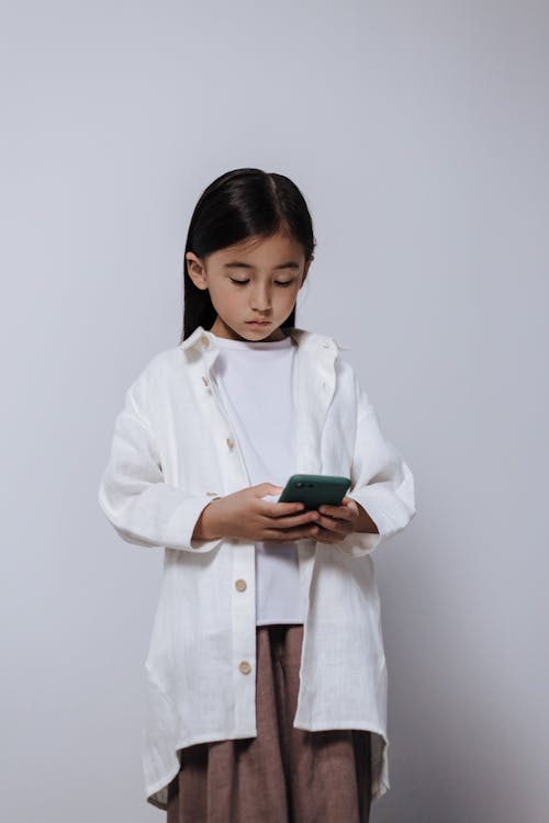 Standing girl in lab coat holding smartphone