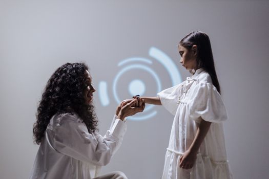 A mother and daughter connect through digital technology in a modern setting.
