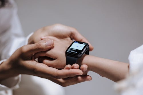 Close up view of hand holding kid hand with smartwatch