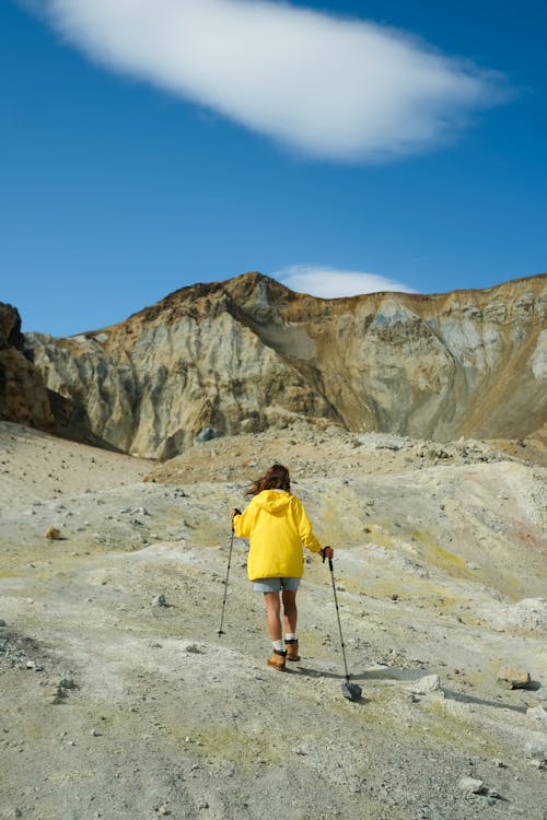 Free Person in Yellow Jacket and Blue Denim Shorts Hiking on the Rocky Mountain Stock Photo