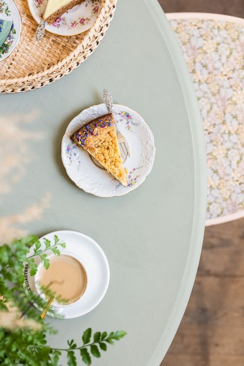 Free Delicate floral themed dessert setting featuring cake slice and coffee on elegant table. Stock Photo