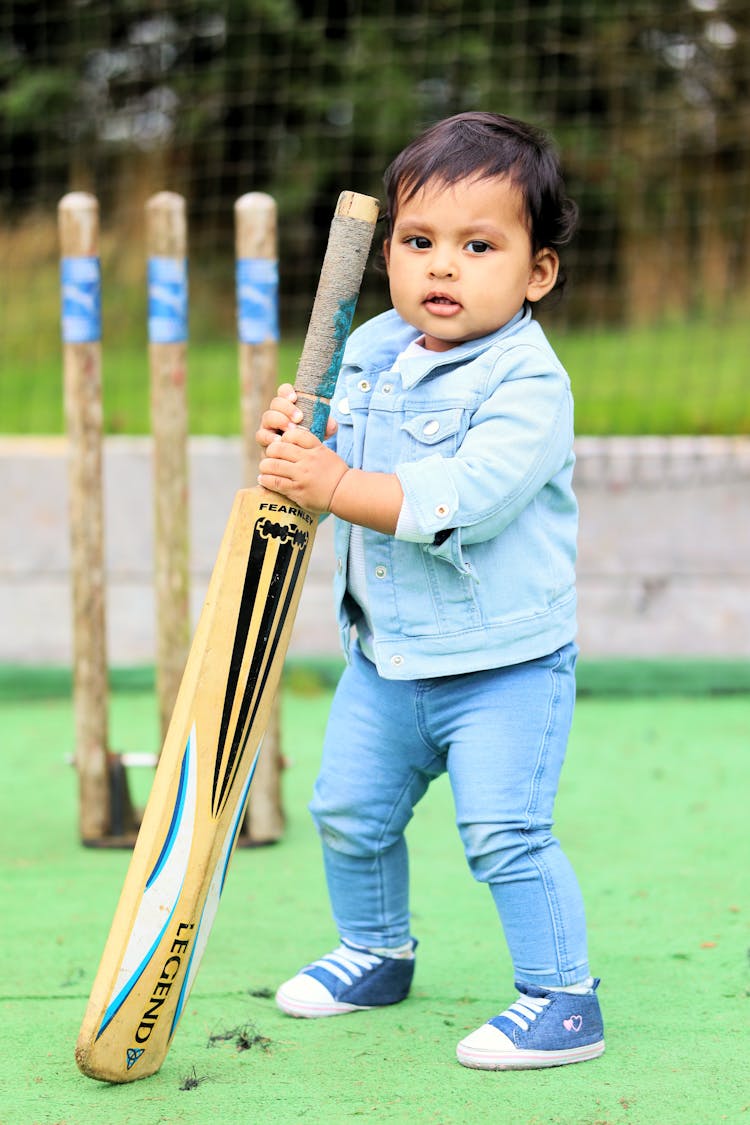 Photo Of A Kid Holding A Cricket Bat