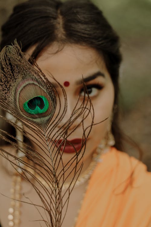 Woman Holding a Peacock Feather