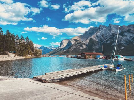 Dramatic landscape of Moraine Lake with mountains and cloudy sky in Banff National Park, Canada.