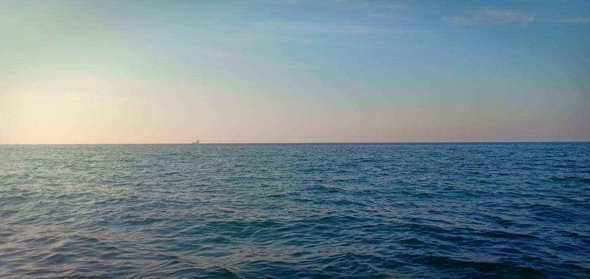 Smart thermostat on a wall being adjusted by a hand