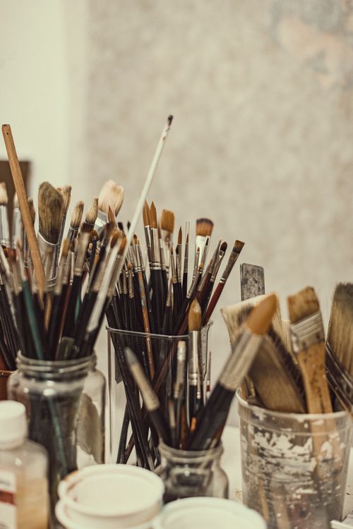 Free Close-up of assorted paintbrushes in glass jars, perfect for artistic concepts. Stock Photo