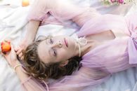 Woman in Pink Dress Lying on White Bed