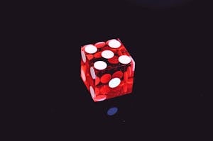 Red Translucent Die on Top of Black Surface
