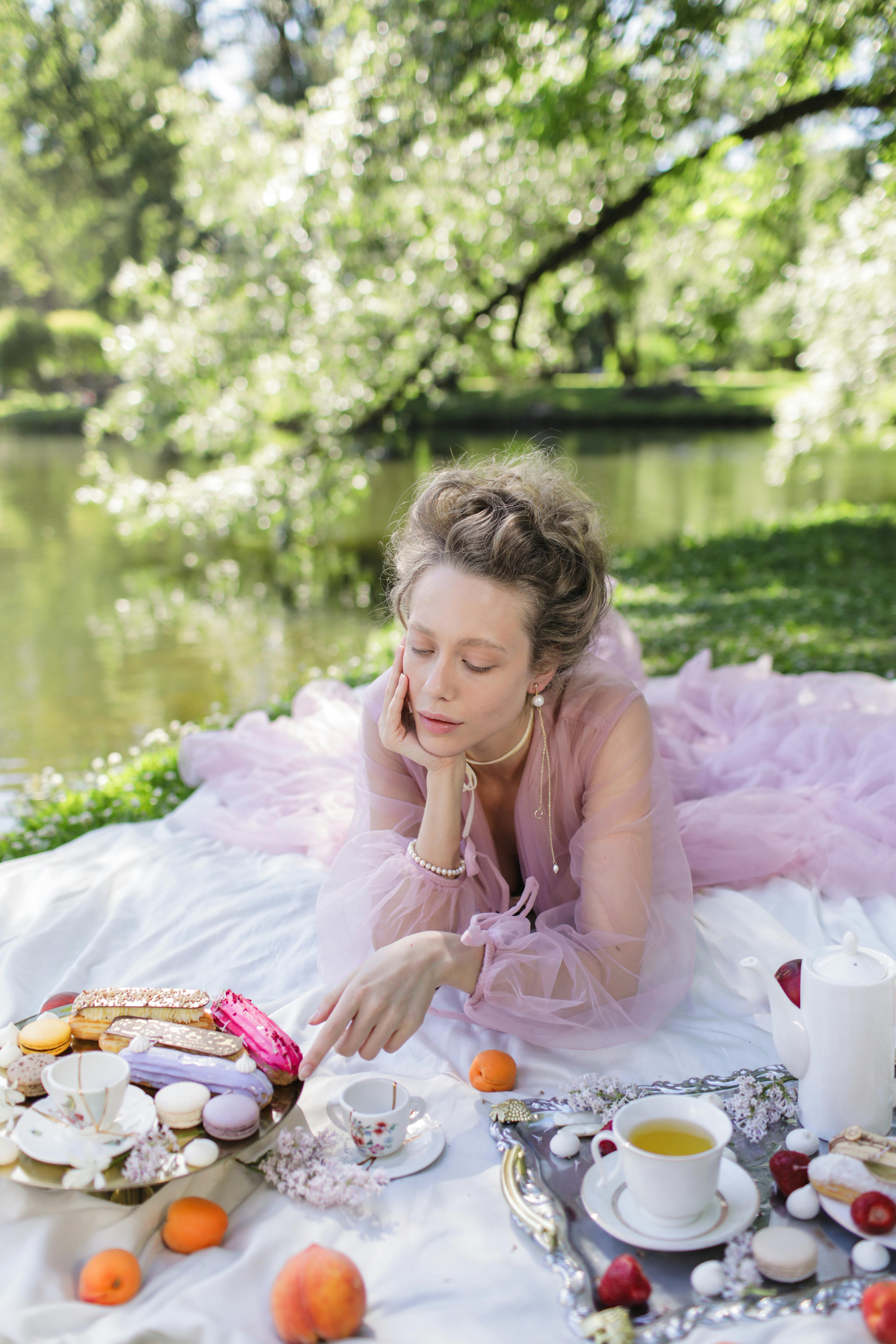 春天，一位女士在宁静的湖边享受奢华野餐，周围环绕着大自然