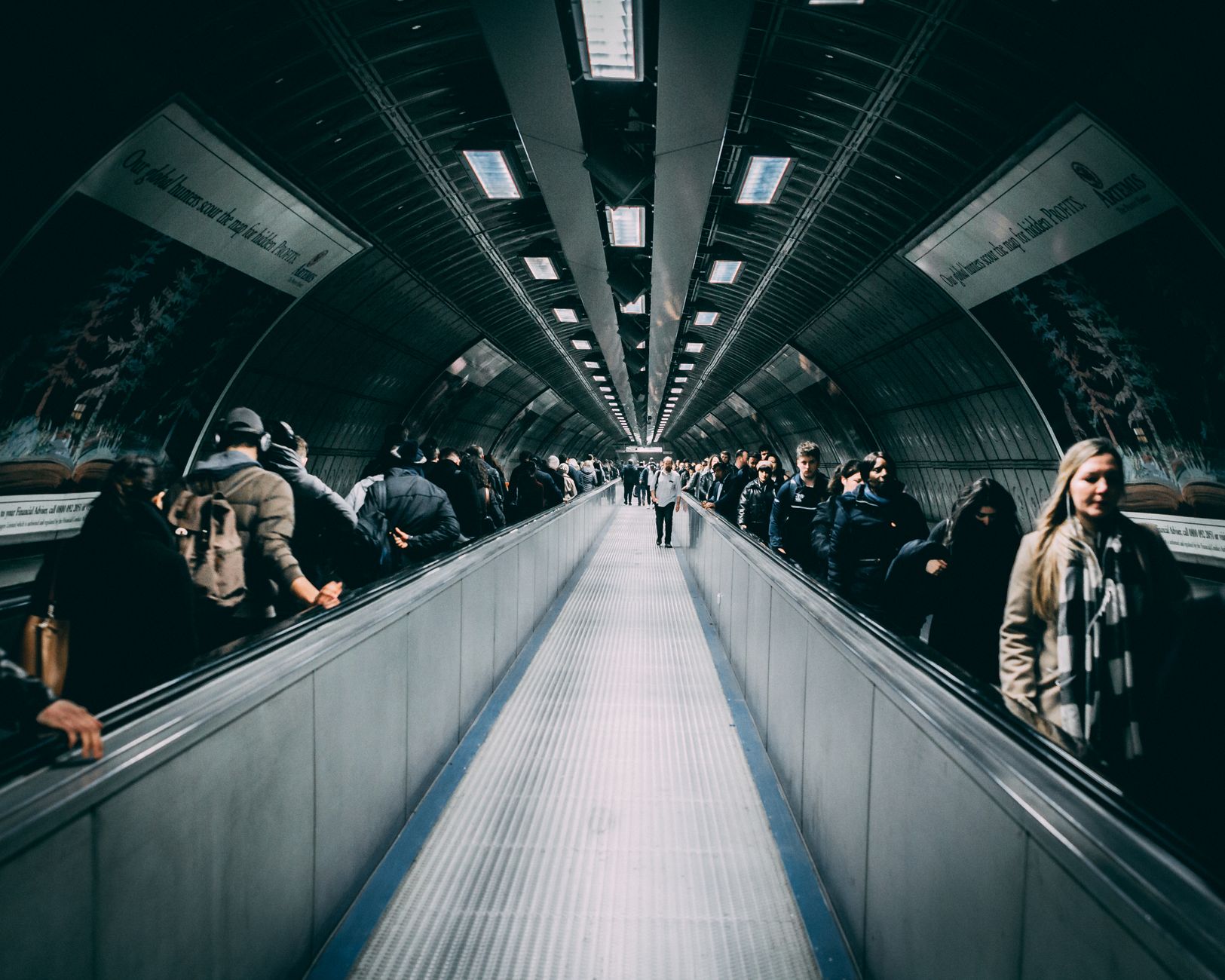 Busy underground walkway in London with commuters during day hours.