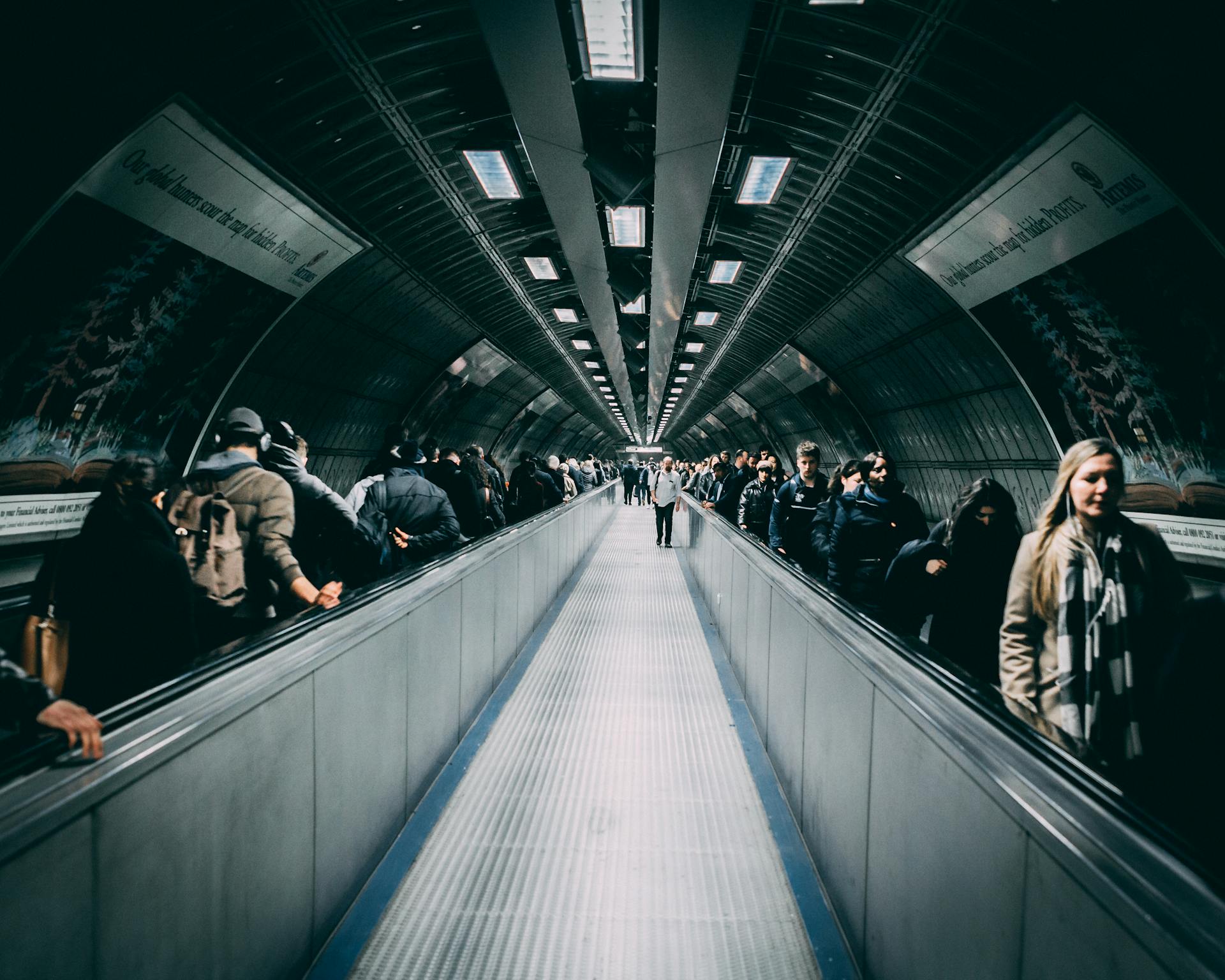 Busy underground walkway in London with commuters during day hours.