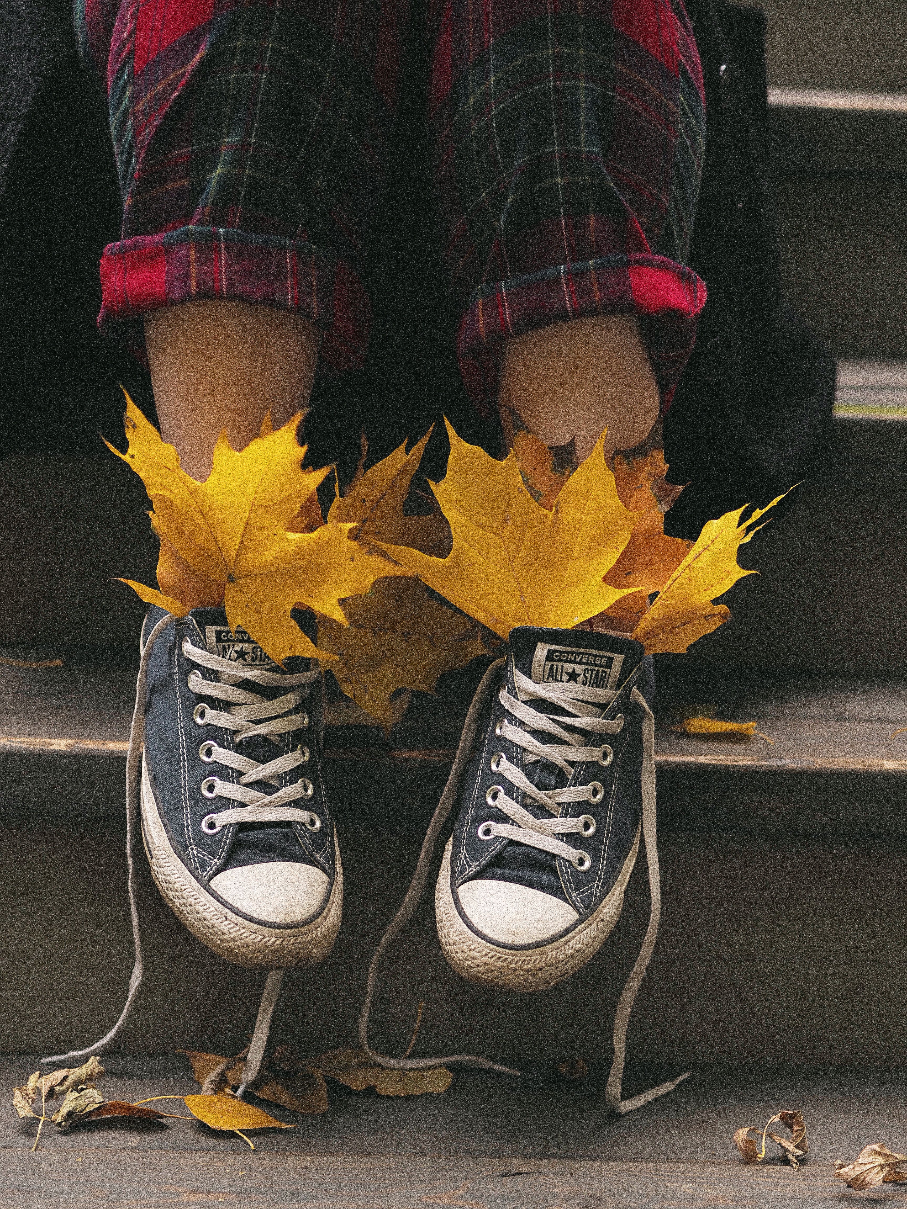 Relaxed fall vibe with untied sneakers and vibrant yellow leaves on stairs.