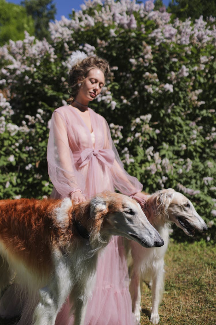 A Woman Standing Beside Her Pet Dogs