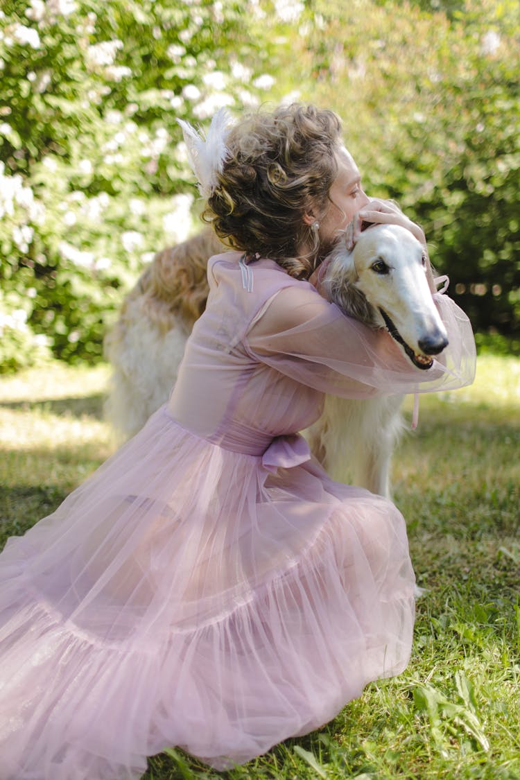 Woman In  Pink Dress Hugging A Dog