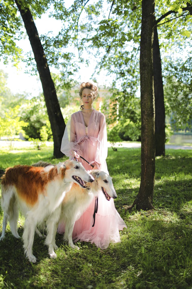 A Woman Standing Beside Her Pet Dogs 