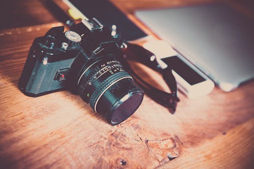 Black Nikon Dslr Camera on Brown Wooden Table