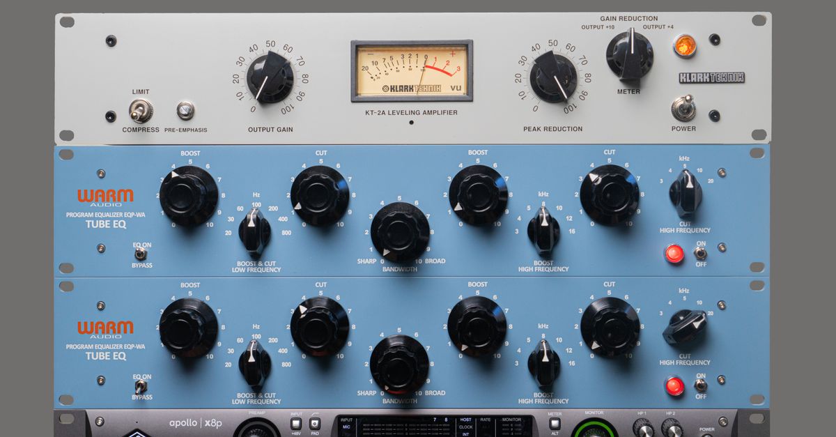 Close-up of studio audio gear with equalizers and amplifier for music production.