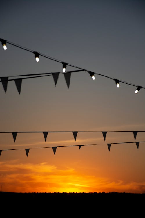 Foto profissional grátis de bandeirinhas, céu, pôr do sol