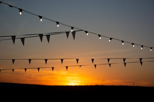 Foto profissional grátis de bandeirinhas, céu, pôr do sol