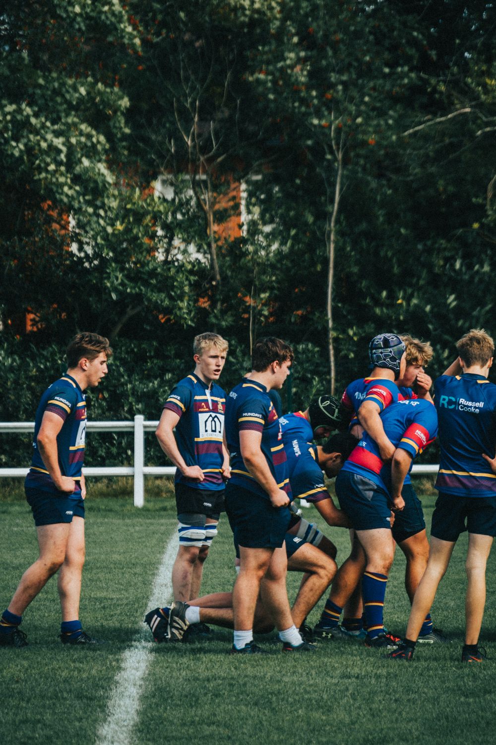 Rugby team in coordinated blue uniforms playing on a field