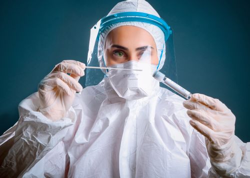 Free A healthcare worker in protective gear holding a syringe, illustrating focus on safety and medical care. Stock Photo