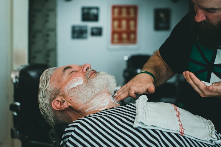 Barber Applying Shaving Cream To Client Neck