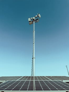 Solar panel with a light post extending into a clear blue sky, highlighting clean energy.