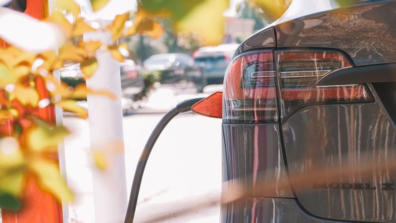 electric vehicle plugged into a fast charging station at a highway rest stop