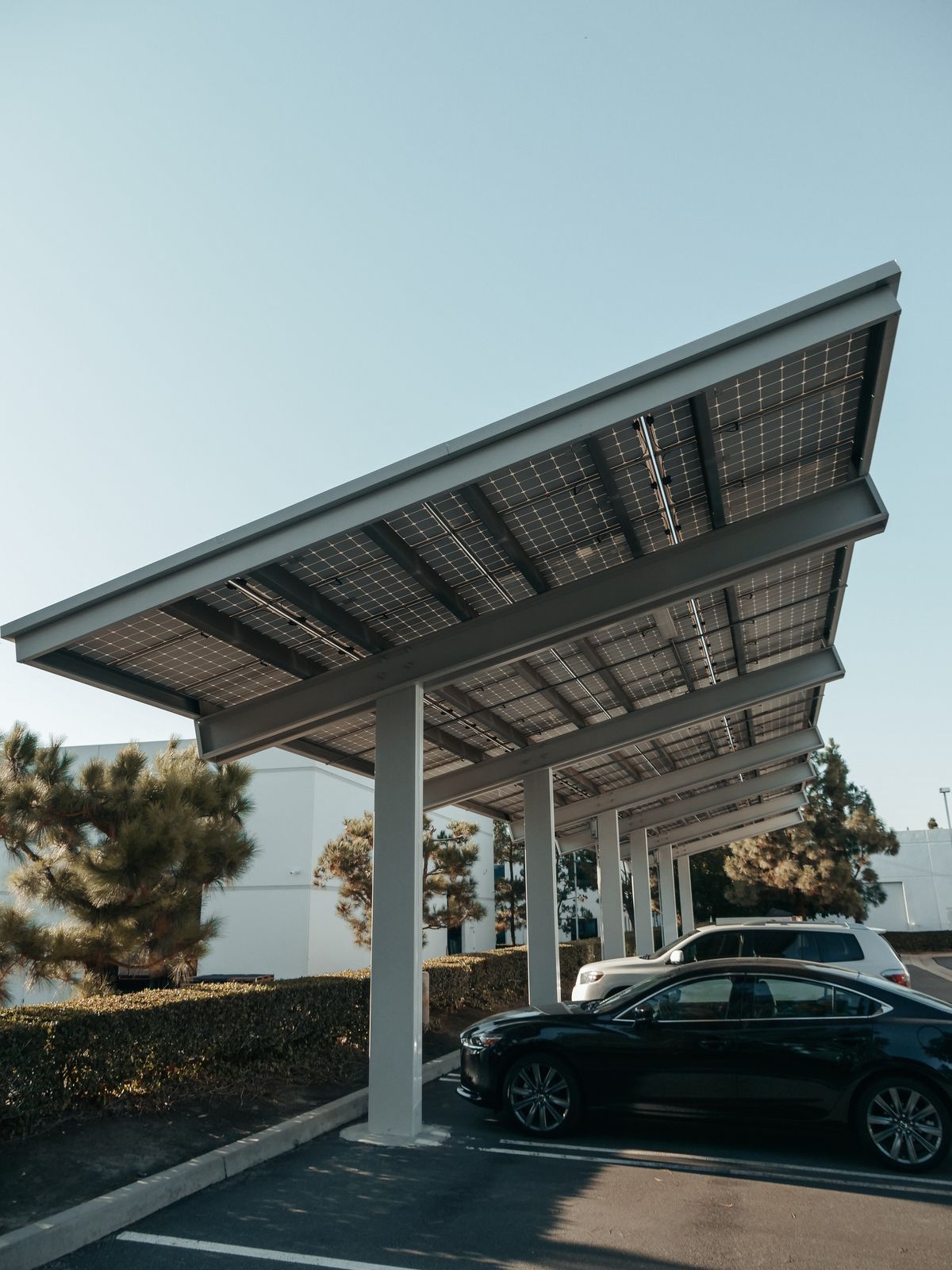 Voitures garées sous des ombrières de parking photovoltaïques
