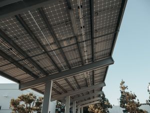 Solar panels seen from below against a clear sky. Photo by Kindel Media on Pexels.