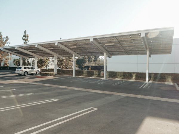 Steel carport with solar panels over parking spaces