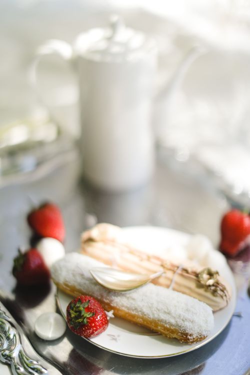 Free Elegant display of coated pastries with fresh strawberries on a reflective tray. Stock Photo