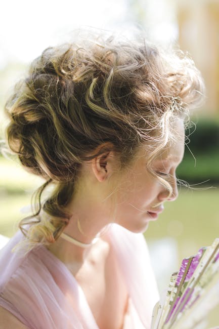 Close-up side profile of a woman with curly hair outdoors, exuding elegance and grace.