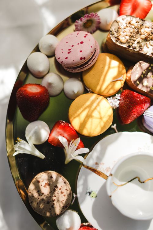 Free Close-up of colorful macarons and strawberries on a decorative plate. Stock Photo