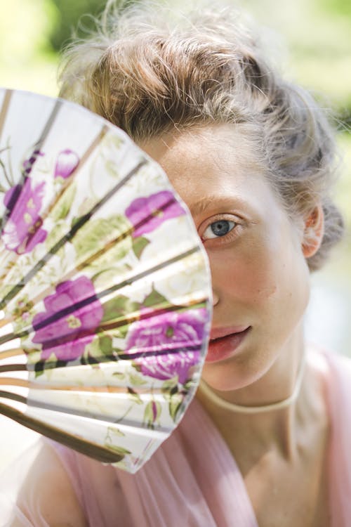 A Woman Covering Her Face with a Hand Fan