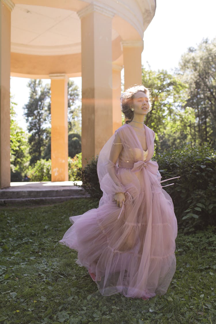 A Woman Wearing A Sheer Dress Running Near A Pavilion