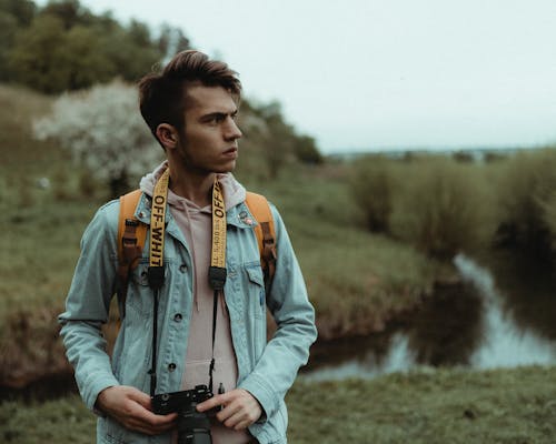 Man in Blue Denim Jacket Holding Black Dslr Camera