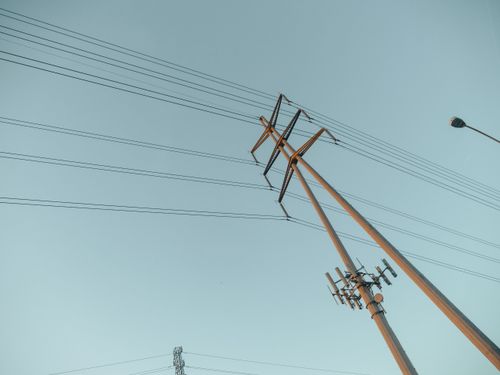 Free A captivating view of power lines stretching into the clear sky during sunrise, symbolizing energy and connectivity. Stock Photo
