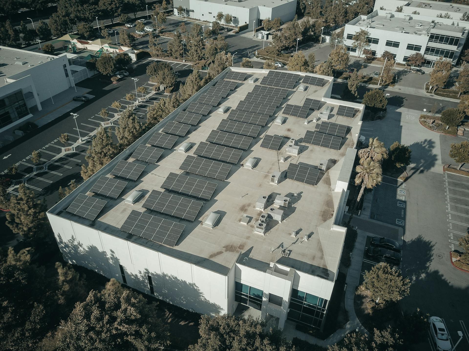 Aerial shot of a commercial building with solar panels, emphasizing renewable energy architecture.