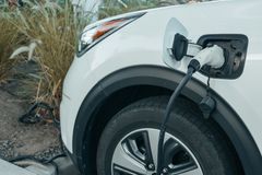 Close-up of an electric vehicle charging at a station, promoting clean energy.