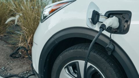 Close-up of an electric vehicle charging at a station, promoting clean energy.