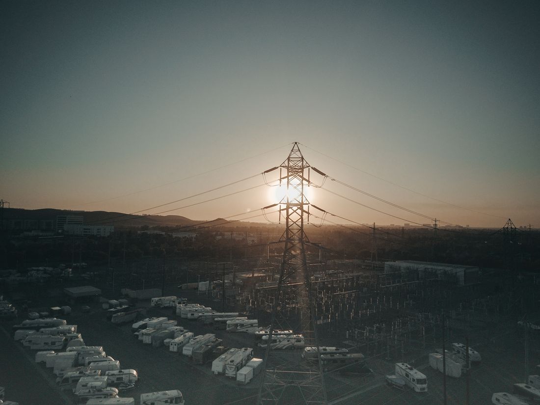High-voltage tower and energy park at sunset — photo by Kindel Media on Pexels
