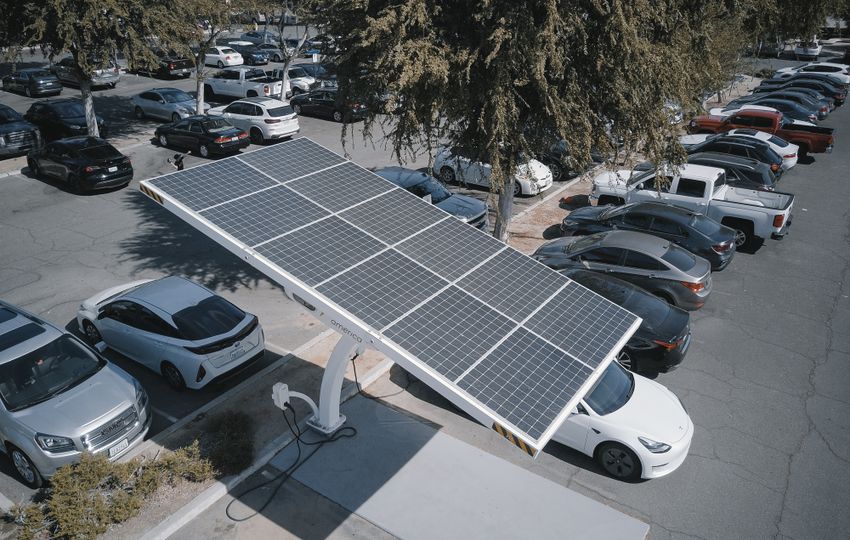 Electric vehicles using a solar-powered charging station — representative real photograph, not an ESPC project