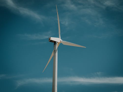 Free Wind turbine generating renewable energy under a clear blue sky, symbolizing sustainability. Stock Photo