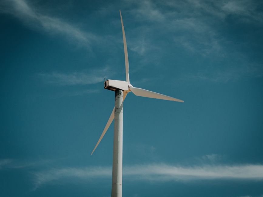 Fotomural Turbina eólica generando energía renovable bajo un cielo azul claro, simbolizando la sostenibilidad.